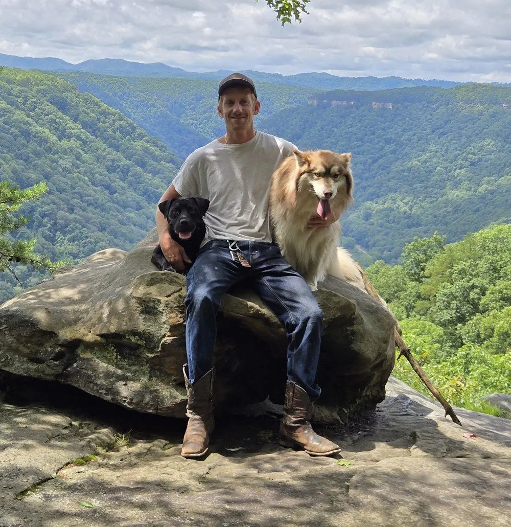 Jonnie, owner and pilot of Apex UAV, with his dogs Bella and Coco at a mountain overlook