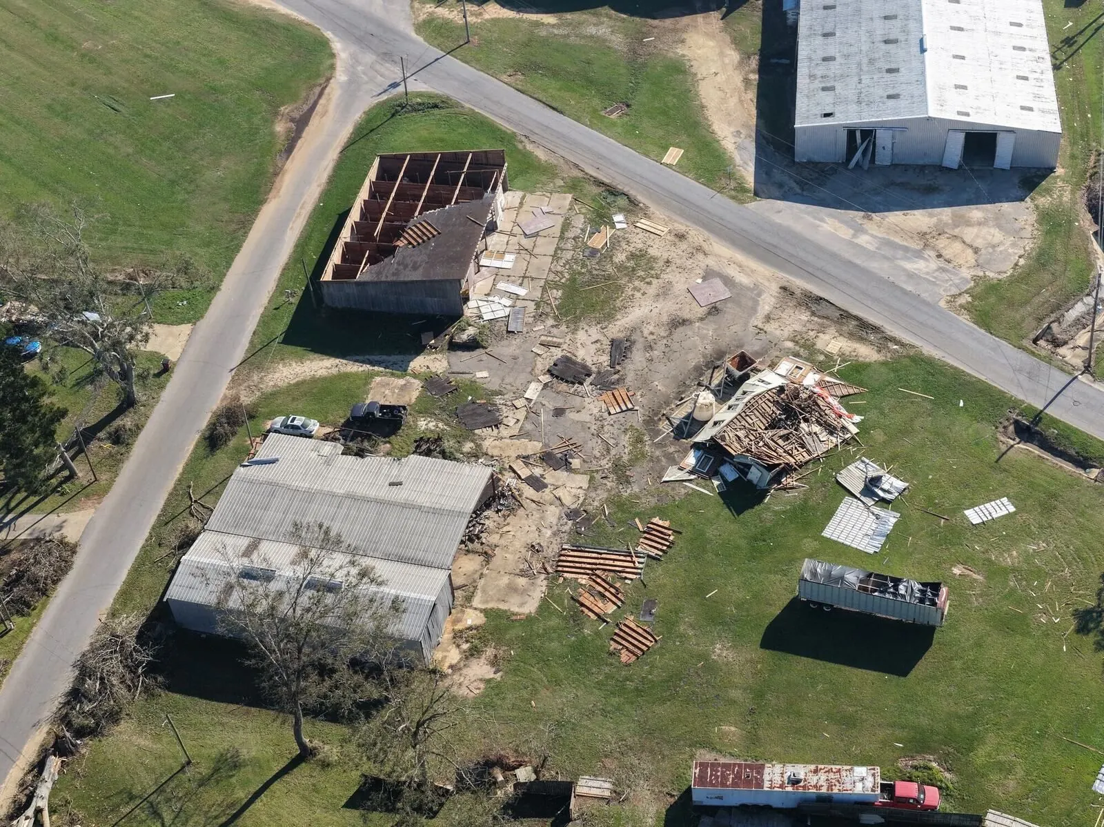 Aerial view of buildings and a lot with wind damage