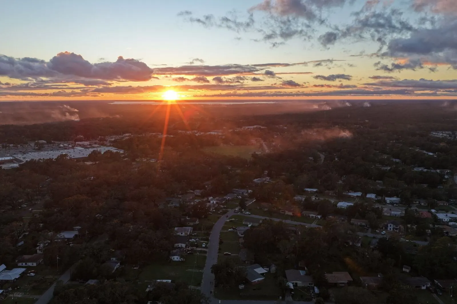 Aerial view of land and treetops at sunset